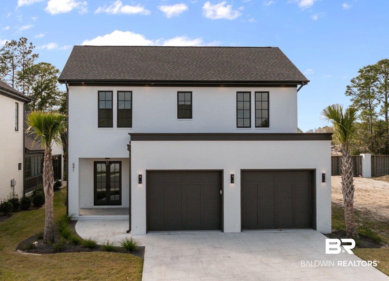 Image 1: View of front of house with decorative driveway, an attached garage, and stucco siding