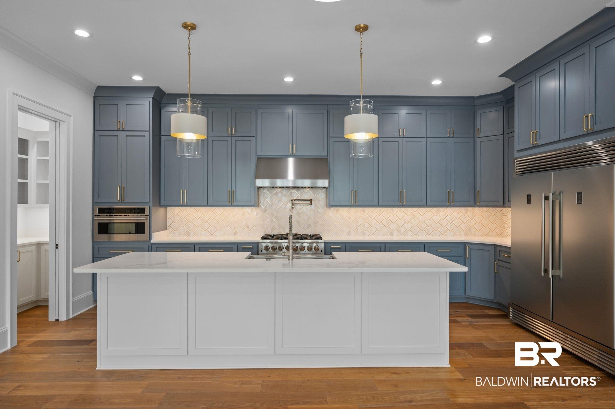 Image 4: Kitchen with stainless steel appliances, tasteful backsplash, a center island with sink, pendant lighting, and recessed lighting