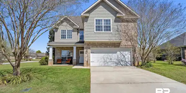 Image 4: Craftsman-style home featuring a front lawn, brick siding, covered porch, a garage, and driveway