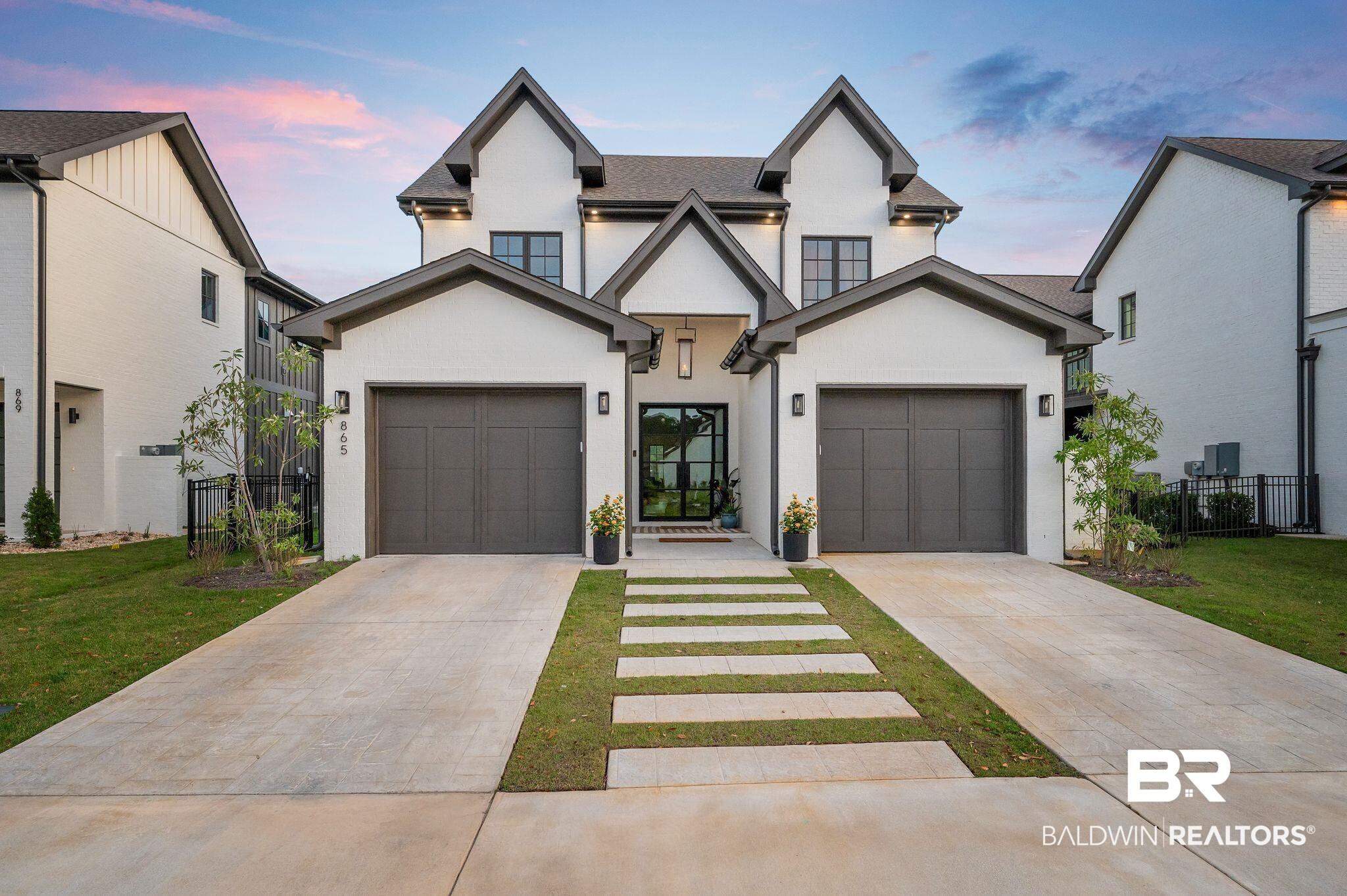 Image 1: View of front of home featuring concrete driveway and stucco siding