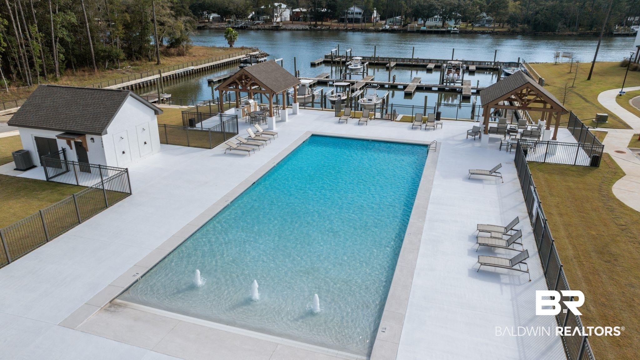 Image 4: Community pool with a water view and a patio