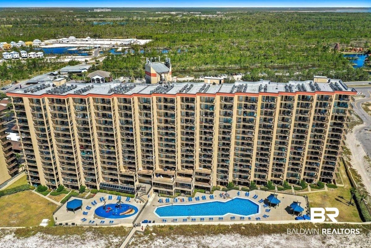 Image 1: Bird's eye view of a pool area and apartment complex
