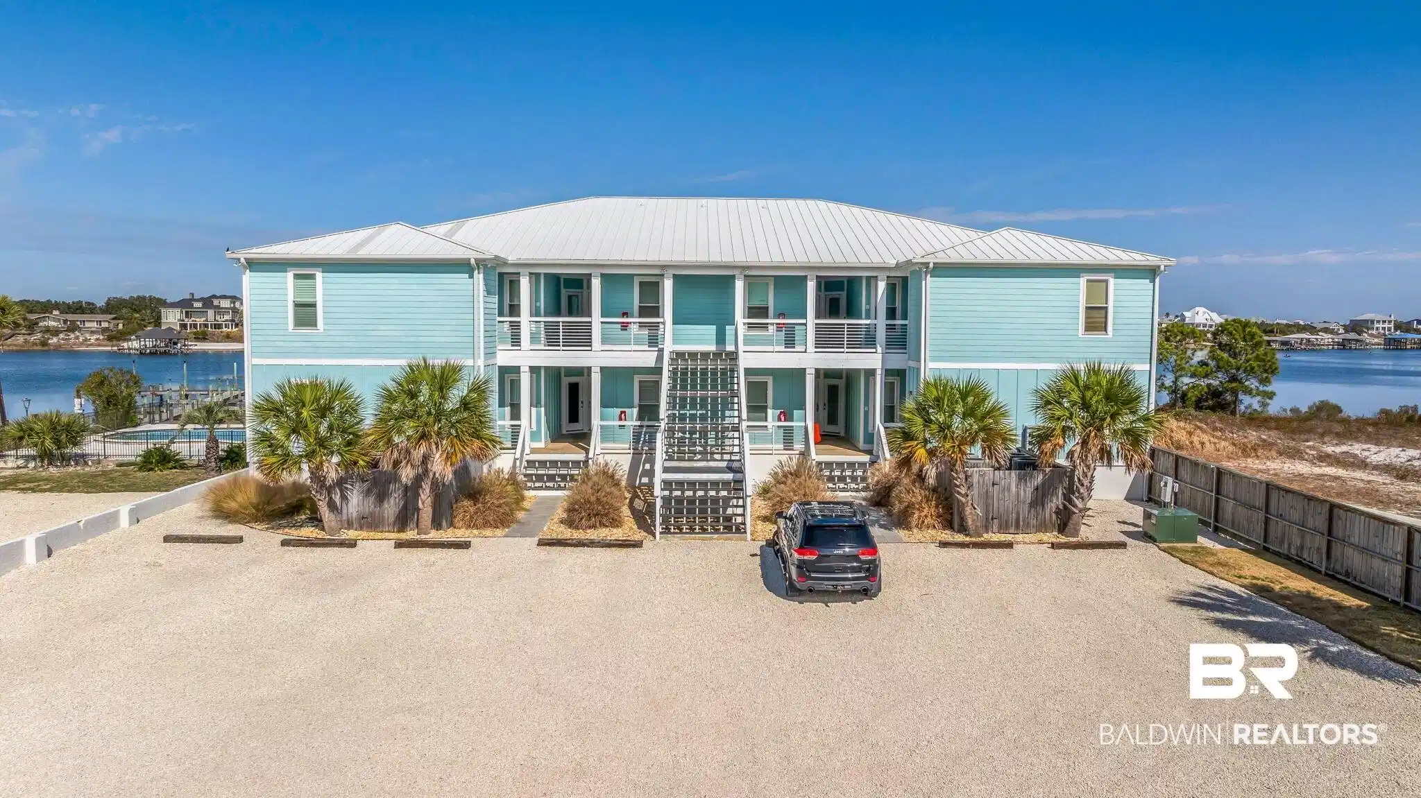 Image 1: Raised beach house with a porch, a water view, and a metal roof