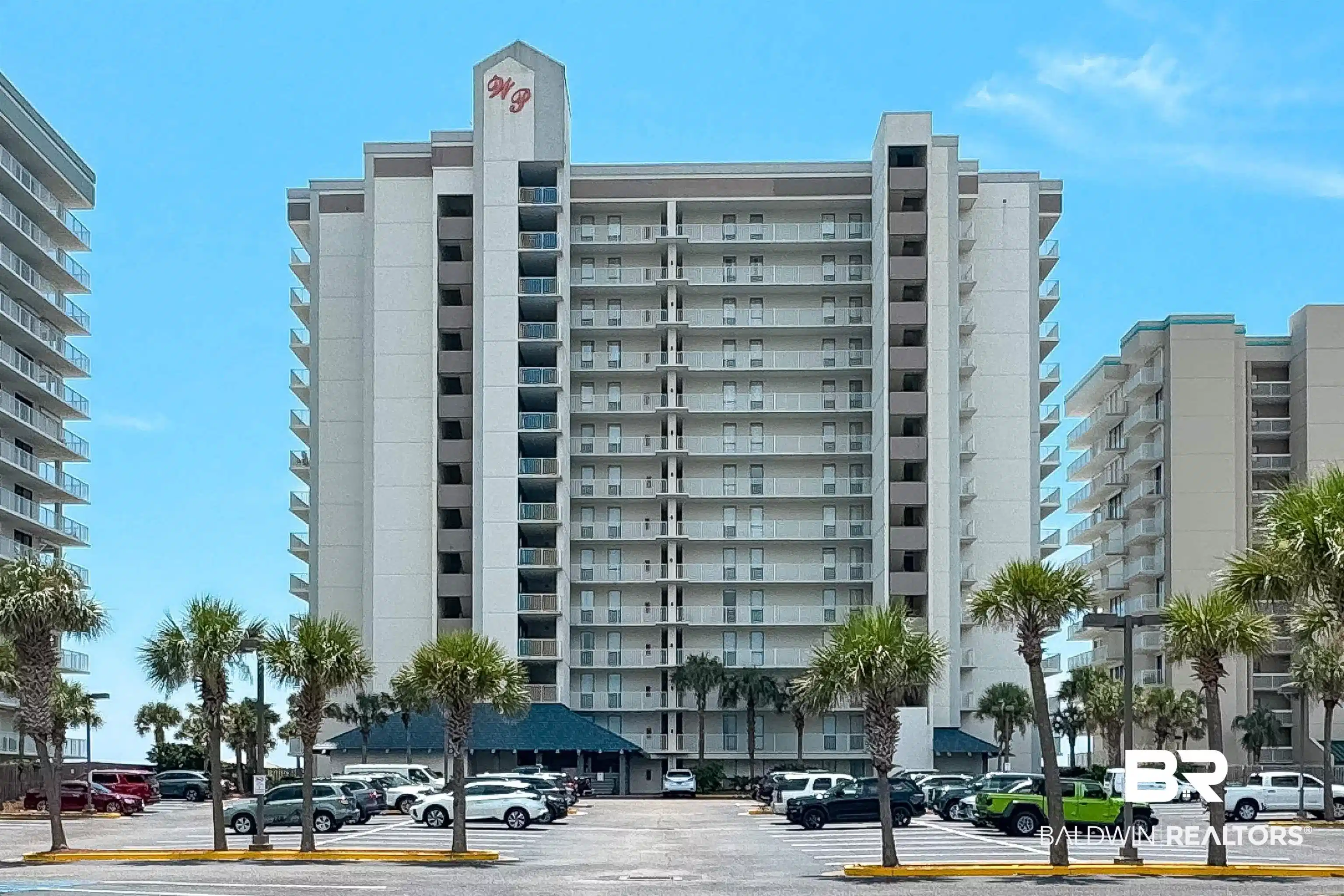 Image 1: High-rise coastal building featuring multiple levels of private balconies, a ground-level covered entrance, and an expansive parking area