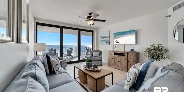 Image 2: Living area featuring a spacious balcony with water views, large sliding glass doors, ceiling fan, and tile flooring