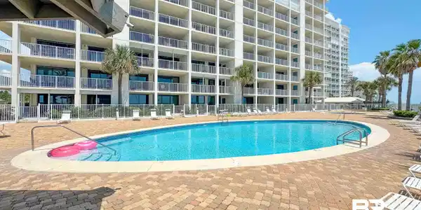 Image 4: Resort-style pool with a curved design and paver decking