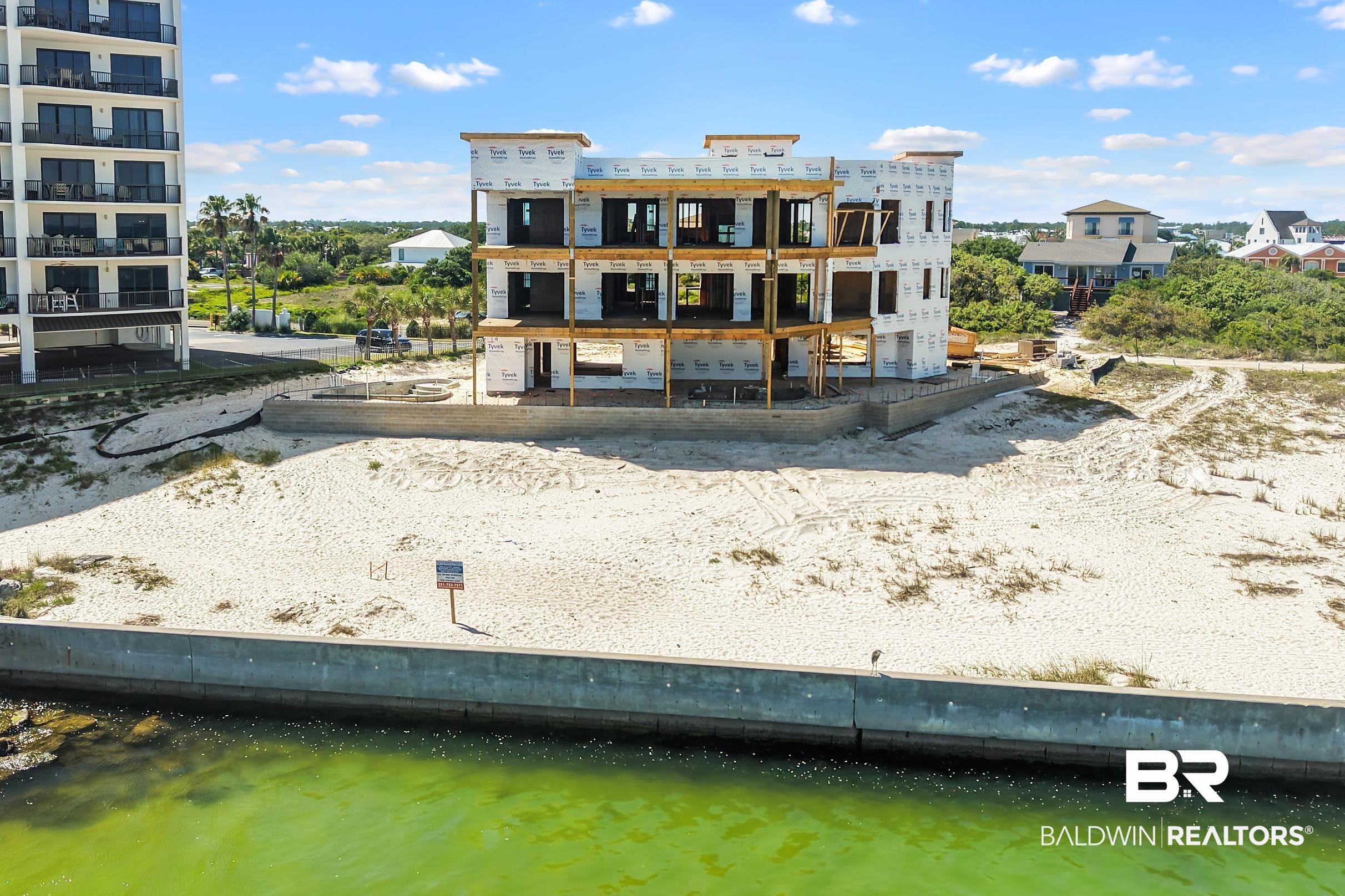 Image 4: Three-story residential structure under construction featuring exposed framing and a waterproof membrane