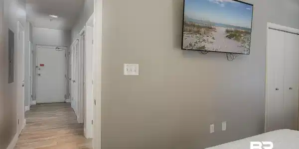 Image 4: Hallway featuring wood-finish flooring, light gray walls, and multiple white doors