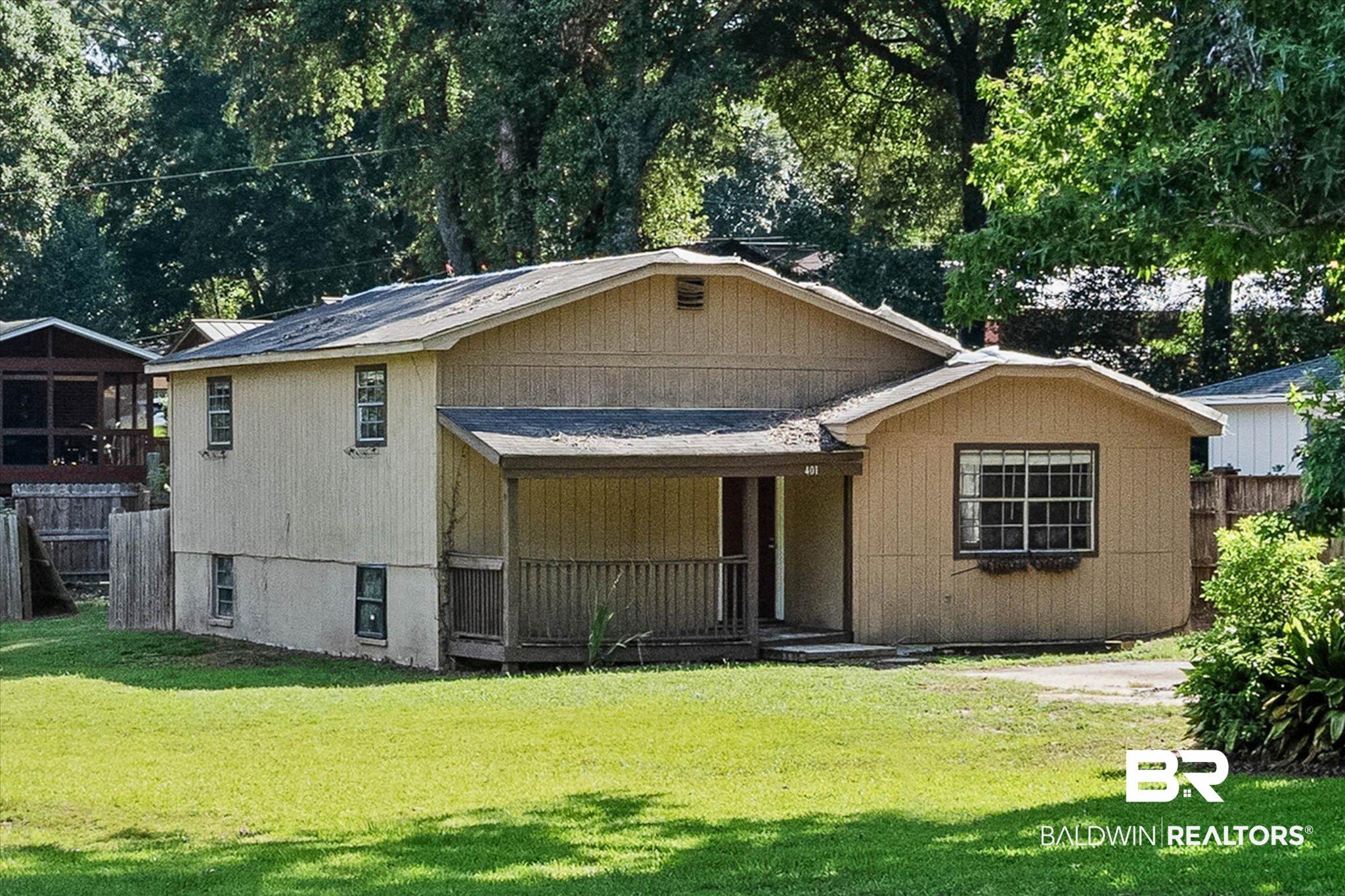 Image 1: Single-family residence featuring wood-paneled siding and a covered front porch