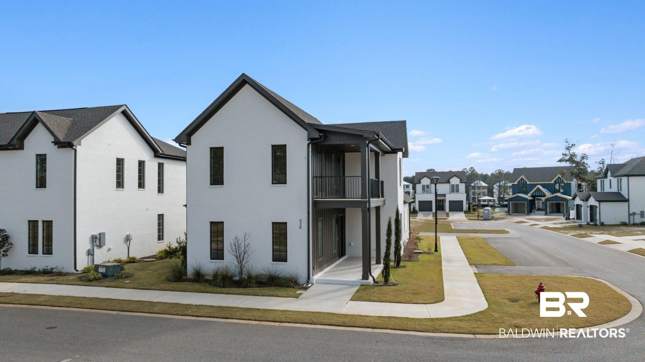 Image 2: View of front of house with a residential view, a balcony, and stucco siding