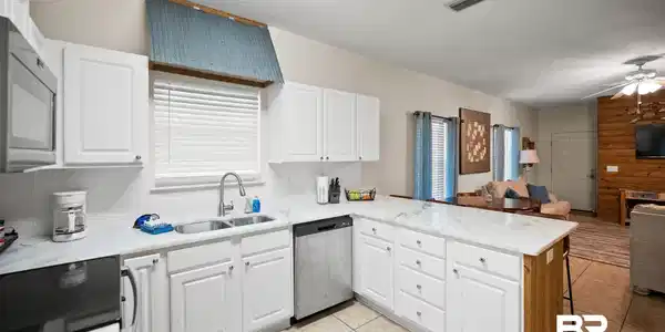 Image 4: Kitchen featuring a peninsula, stainless steel dishwasher, electric stove, healthy amount of natural light, and a textured ceiling