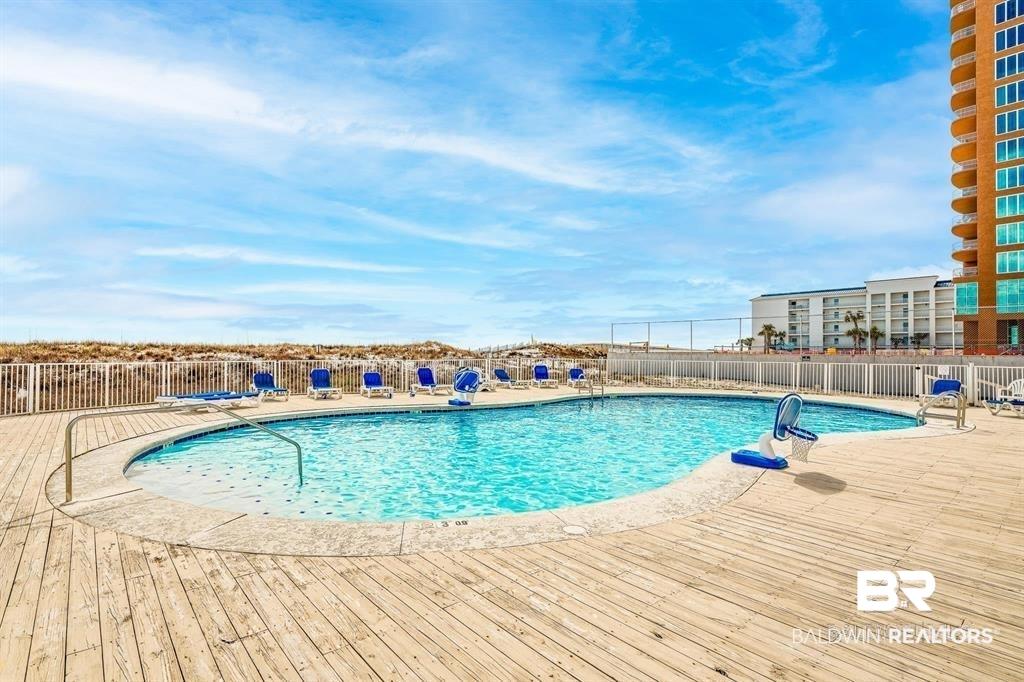 Image 3: Community pool with a patio area and a deck