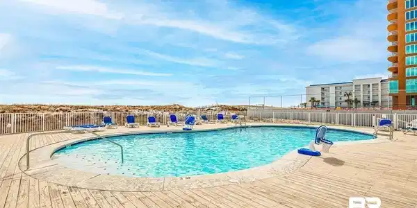 Image 3: Community pool with a patio area and a deck