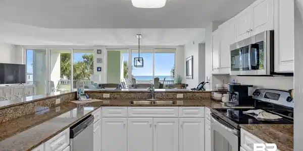 Image 3: Kitchen featuring stainless steel appliances, white cabinets, healthy amount of natural light, dark stone counters, and a textured ceiling