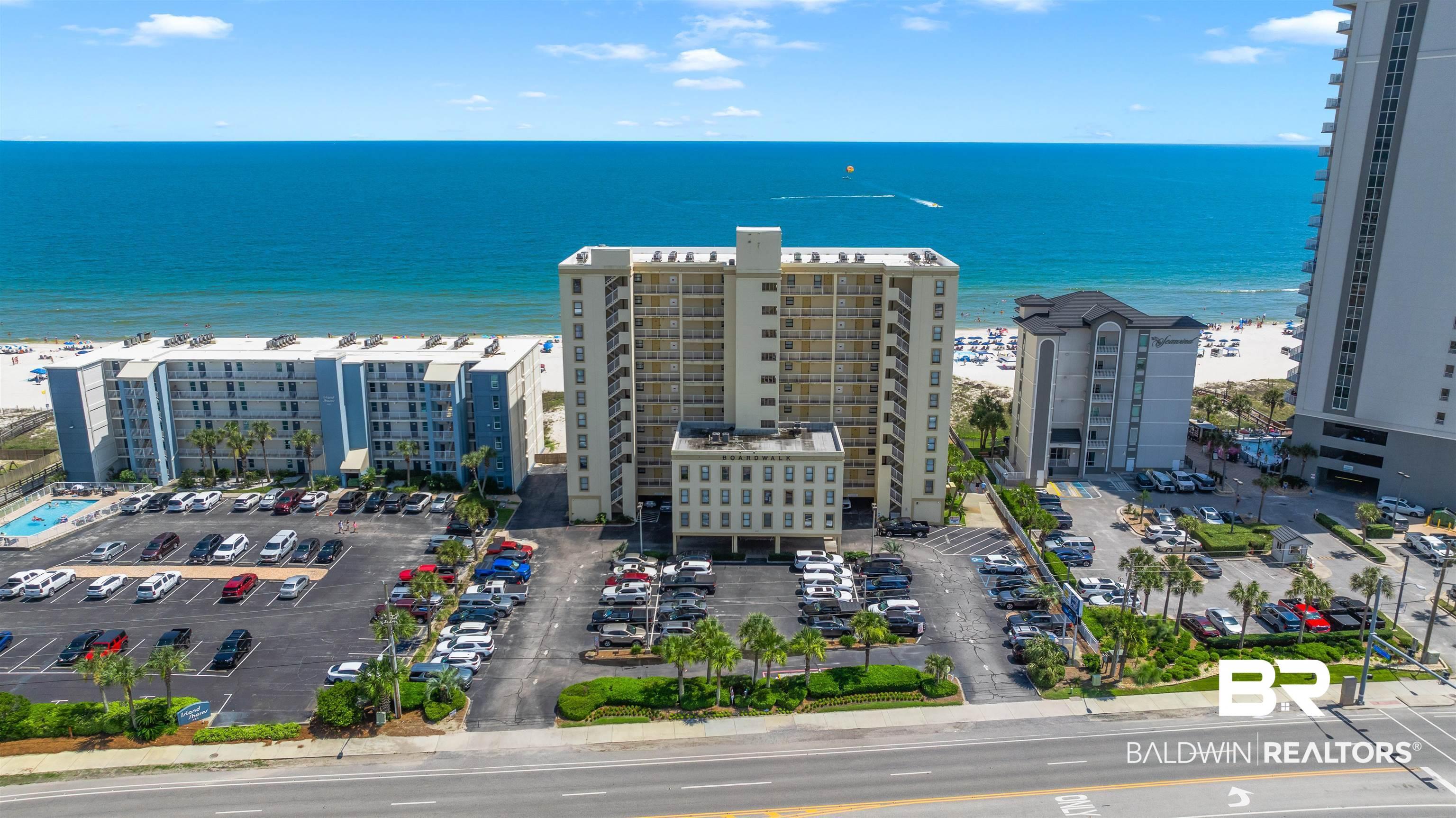 Image 3: Oceanfront property featuring multiple buildings, expansive parking, a pool, and direct beach access