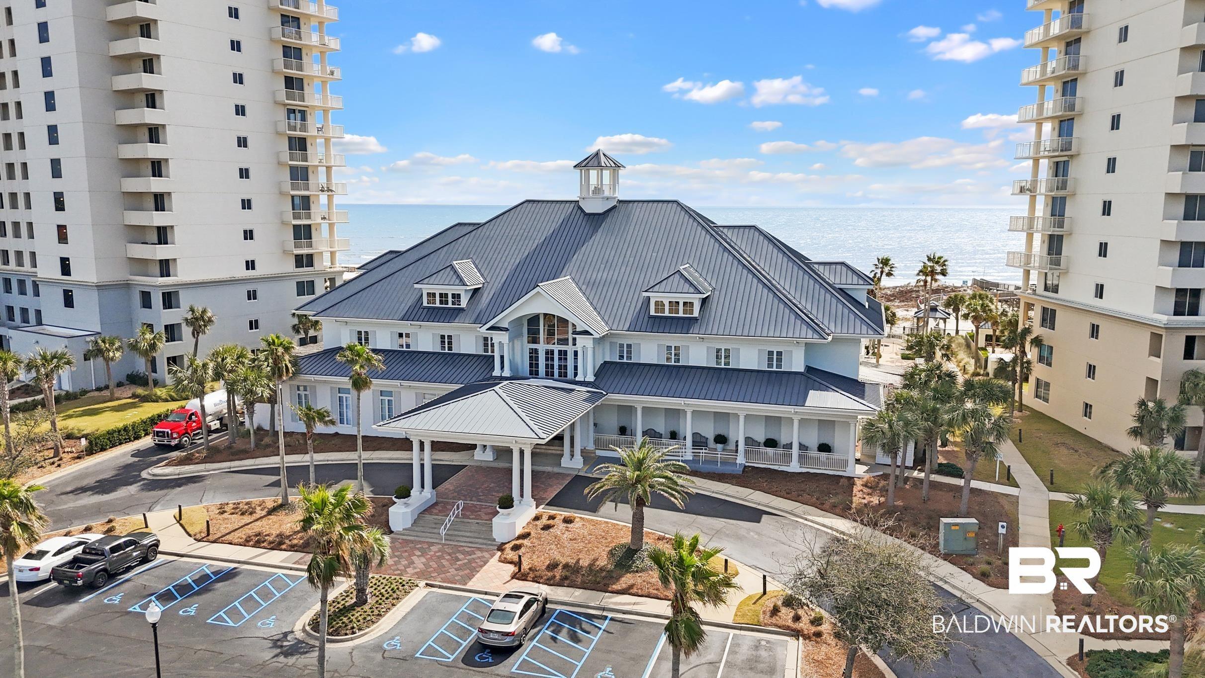 Image 4: View of building exterior featuring uncovered parking and a water view