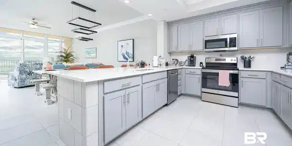 Image 4: Kitchen featuring appliances with stainless steel finishes, gray cabinets, ornamental molding, decorative light fixtures, and a peninsula