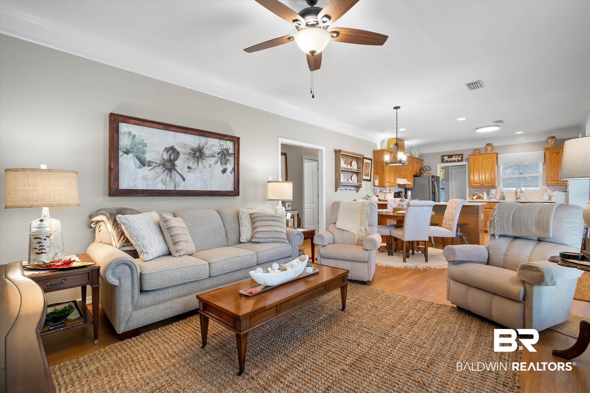 Image 4: Living area featuring crown molding, light wood-style flooring, and ceiling fan