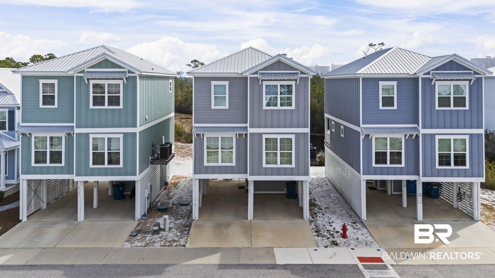 Image 1: Beach home with a carport, a residential view, and driveway