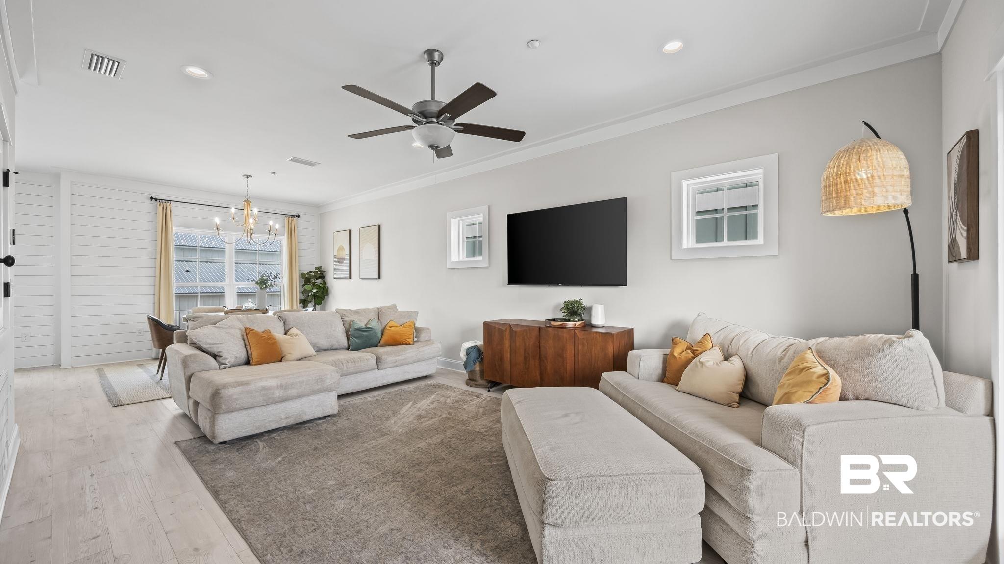 Image 2: Living room featuring hardwood / wood-style floors, a chandelier, a ceiling fan, and ornamental molding
