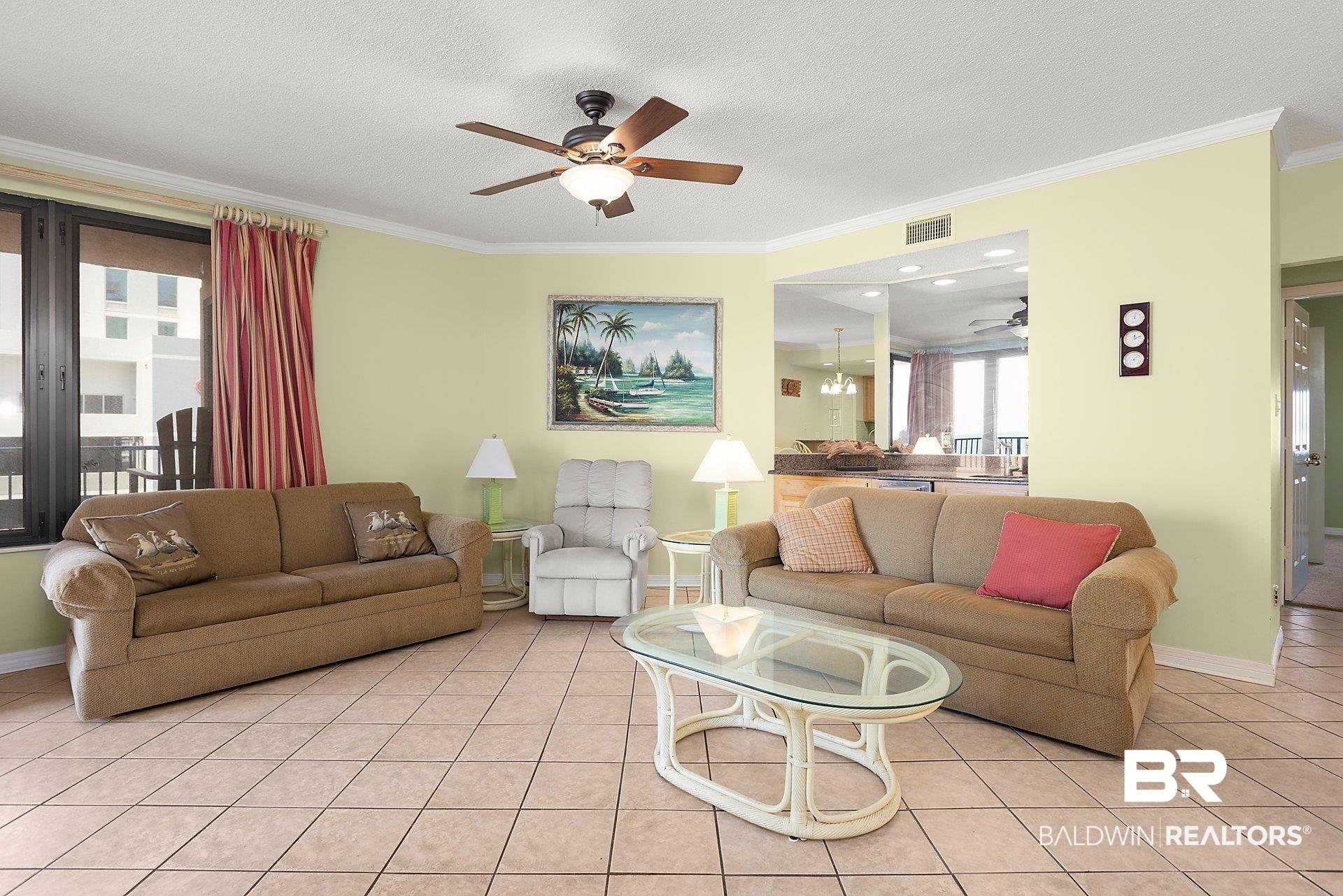 Image 3: Living room with light tile patterned floors, crown molding, a textured ceiling, and a ceiling fan