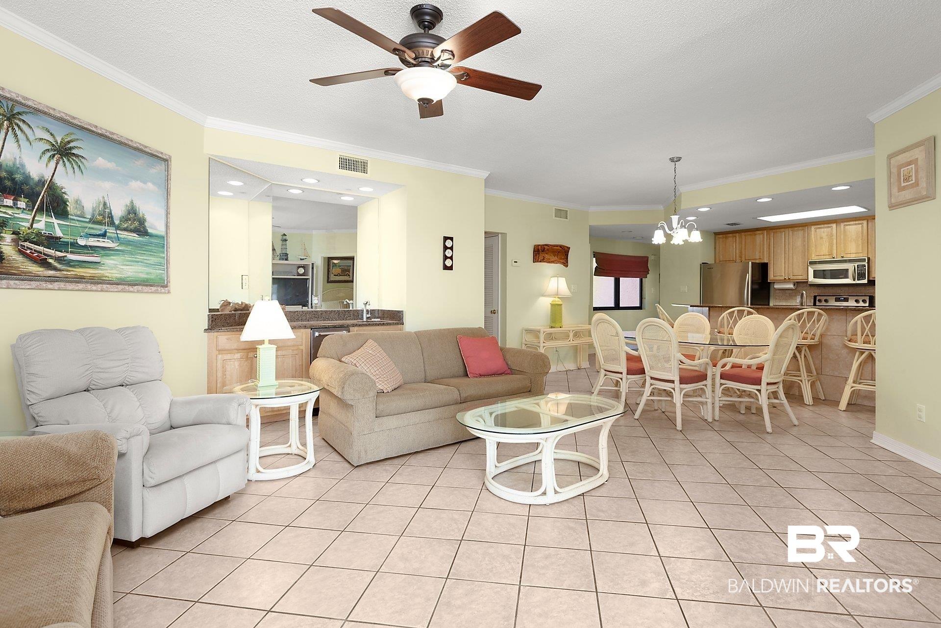 Image 4: Living room with ornamental molding, a chandelier, light tile patterned floors, ceiling fan, and recessed lighting