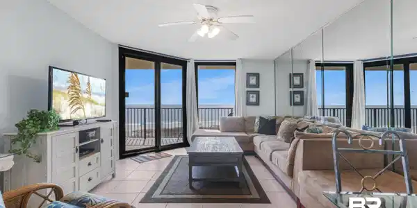 Image 4: Living room with a wall of windows, light tile patterned floors, a textured ceiling, and a ceiling fan