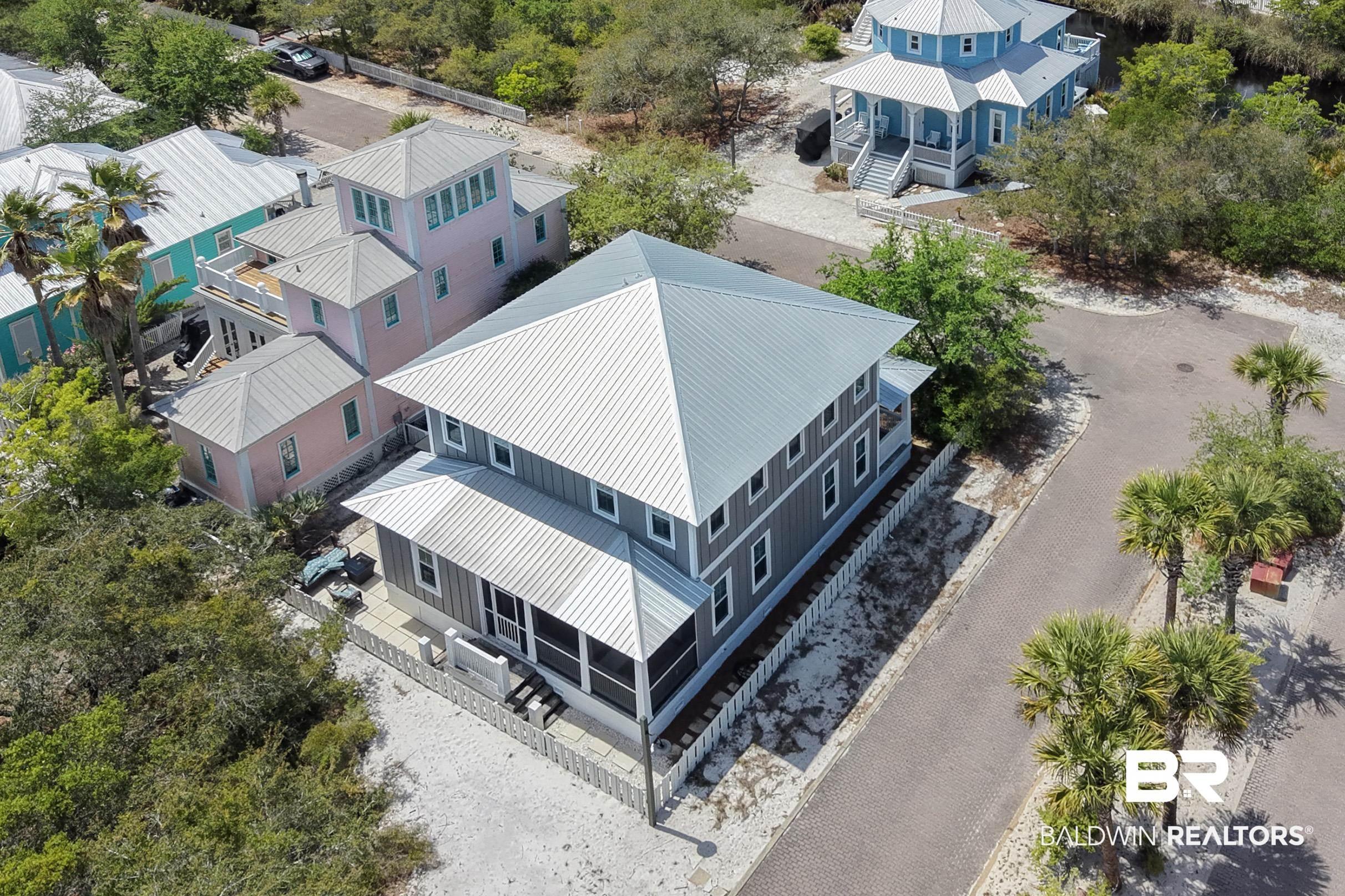 Image 2: Two-story residence featuring a gray exterior with a pitched metal roof