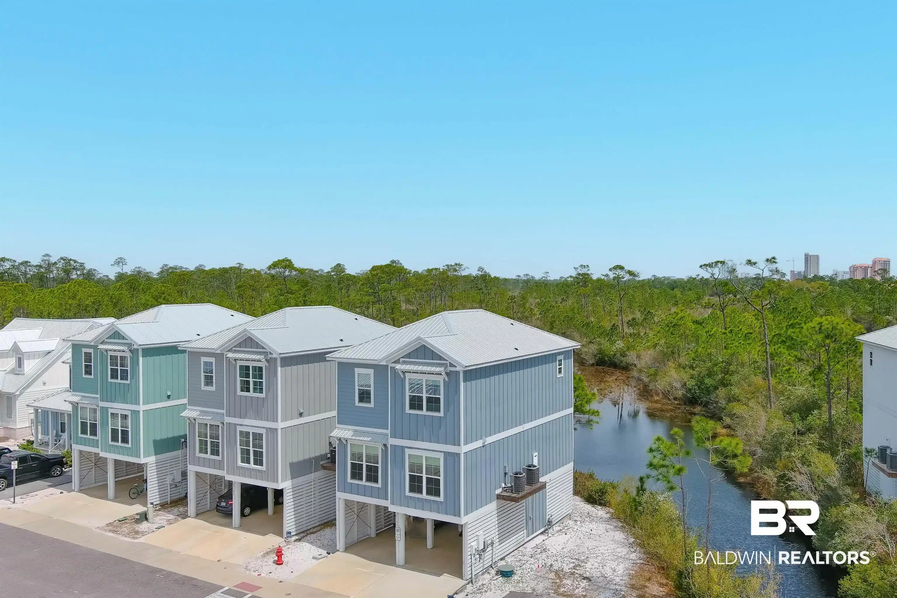 Image 1: Elevated coastal-style homes featuring metal roofs and durable siding