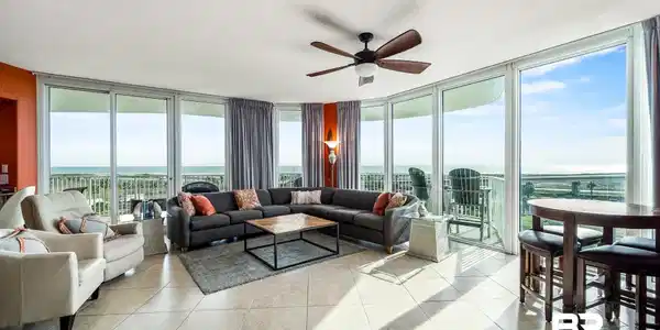 Image 2: Living area with expansive windows, a textured ceiling, ceiling fan, a water view, and light tile patterned floors