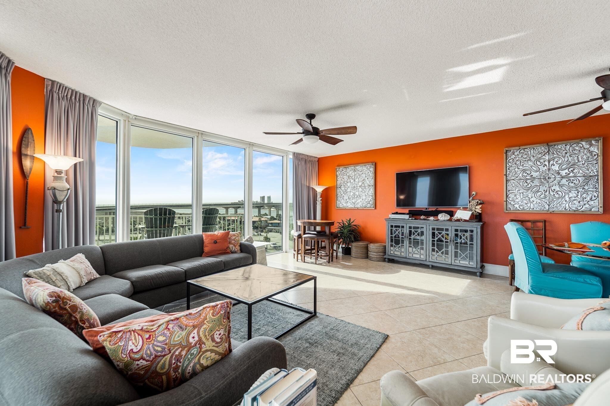 Image 3: Tiled living room with a wall of windows, ceiling fan, and a textured ceiling