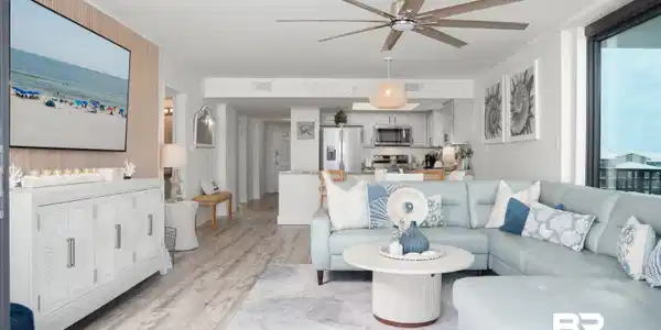 Image 4: Open-concept living space featuring wood-finish flooring, a contemporary ceiling fan, and large windows providing abundant natural light