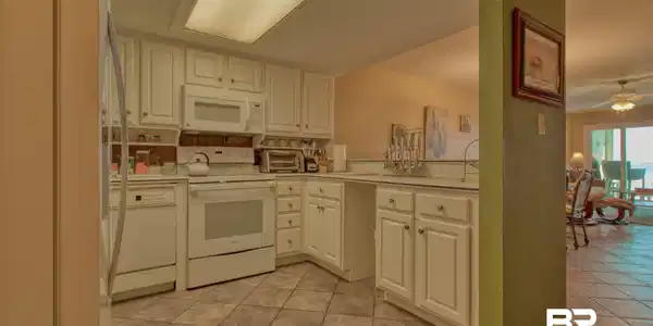 Image 3: Kitchen with light countertops, white appliances, ceiling fan, white cabinets, and light tile patterned flooring