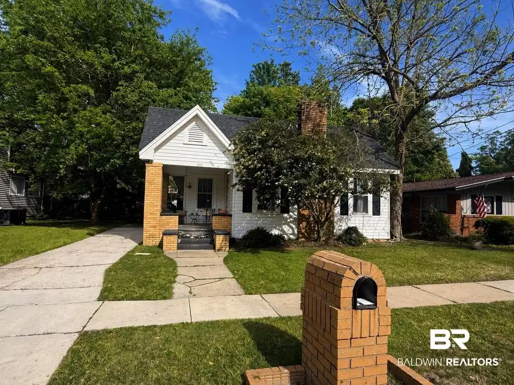 Image 1: View of front facade featuring covered porch, a front yard, and a chimney