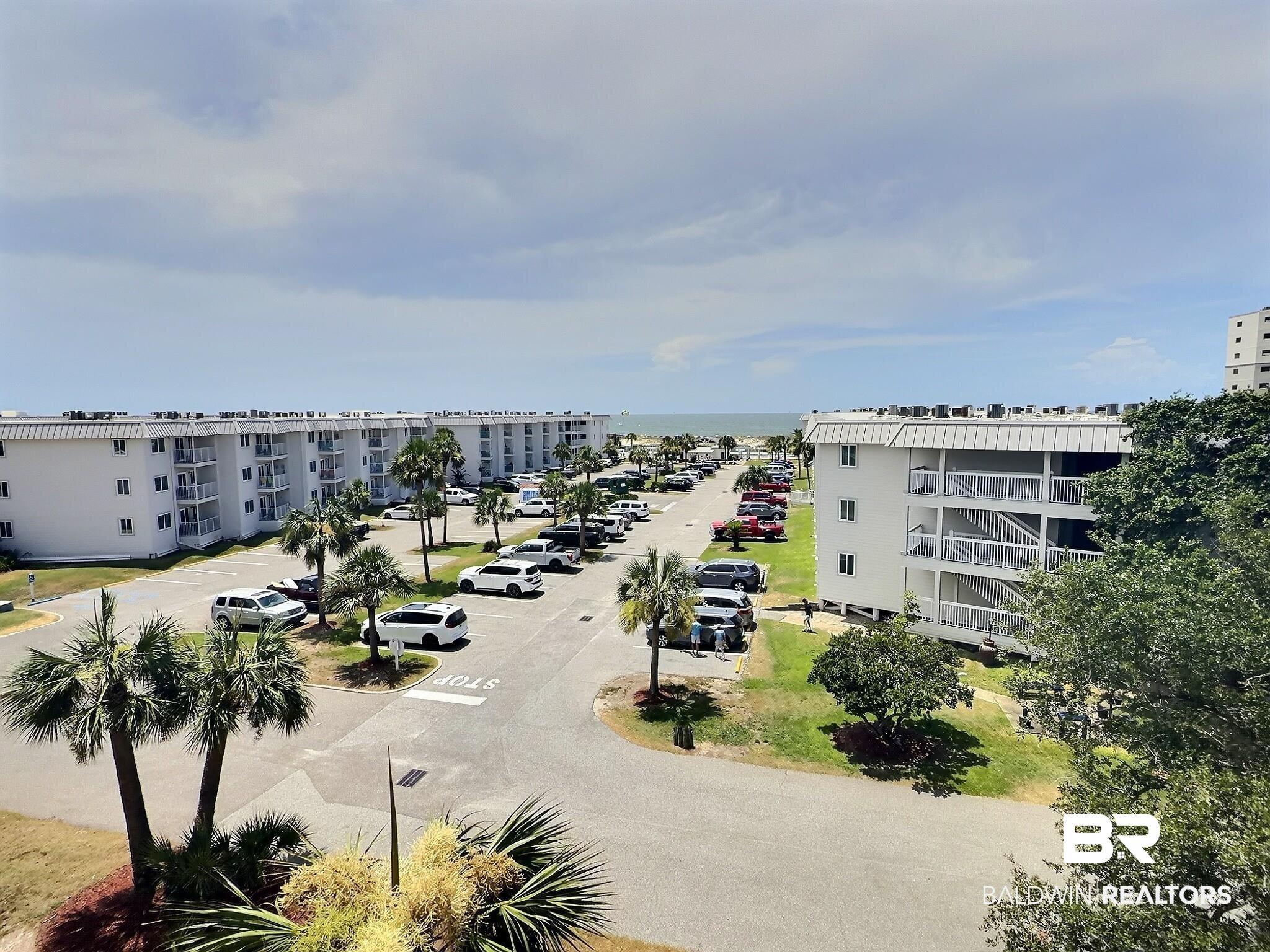 Image 2: Coastal community with multi-story buildings and visible ocean