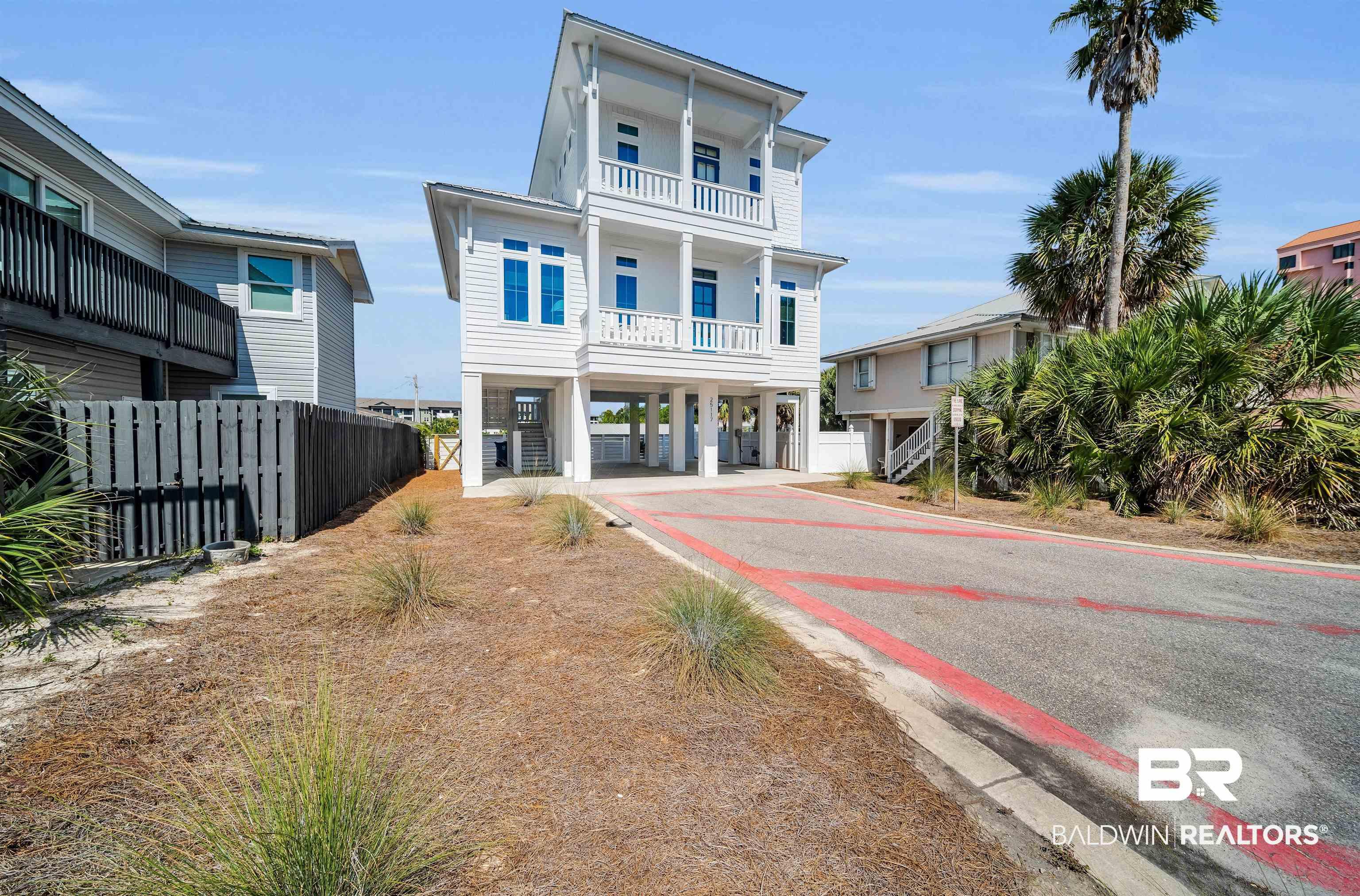 Image 2: Beach home featuring a carport, driveway, and stairway