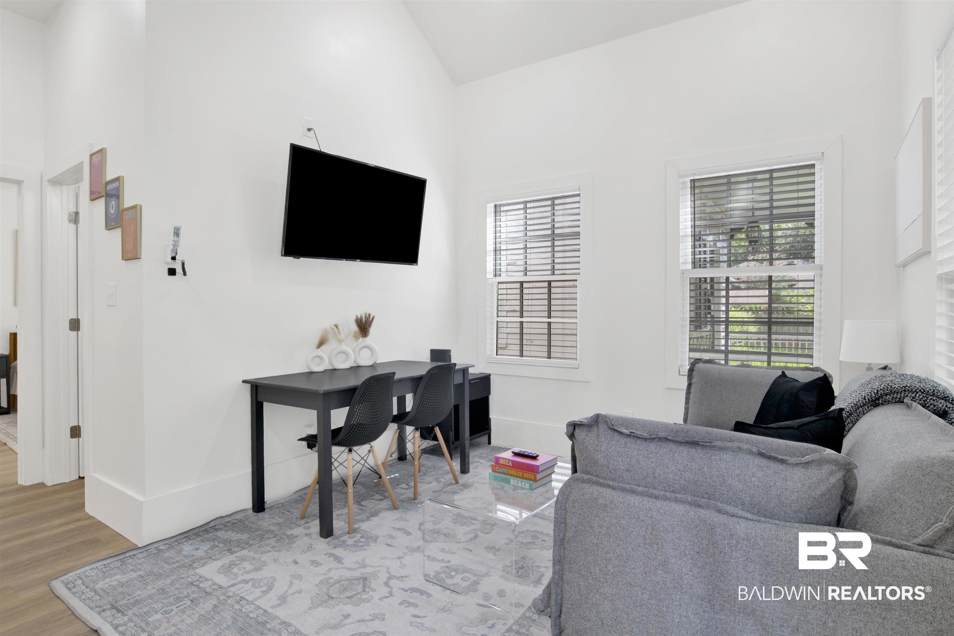 Image 4: Living room with wood finished floors, lofted ceiling, and an office area