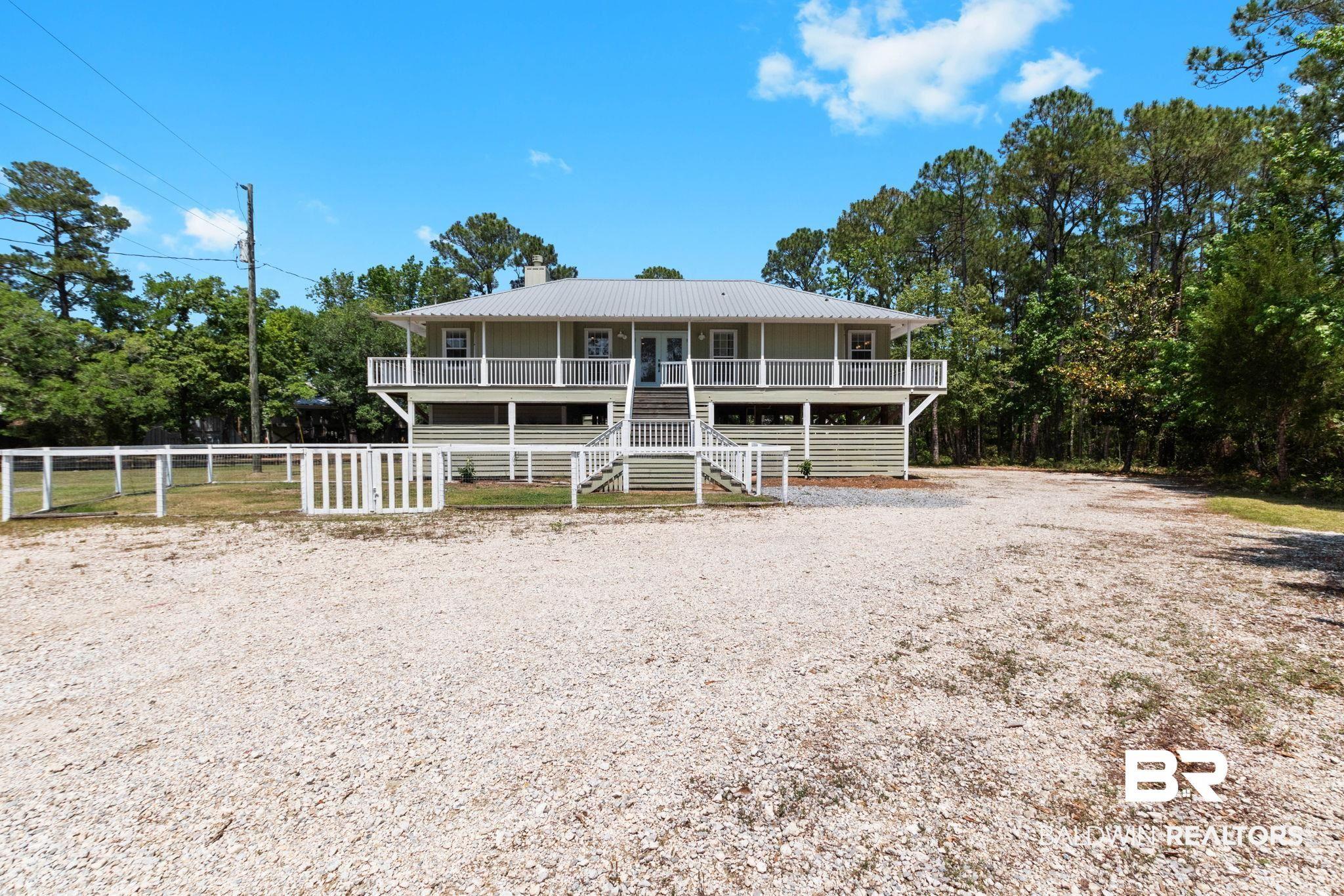 Image 3: Two-story residence featuring a full-width upper balcony and a lower porch, both with white railings