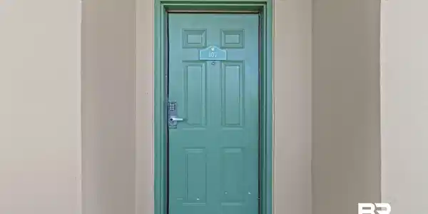 Image 2: Property entrance with stucco siding