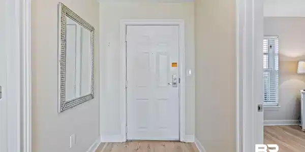 Image 3: Doorway featuring wood finished floors and baseboards