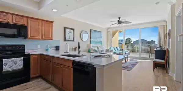 Image 4: Kitchen featuring black appliances, brown cabinets, tasteful backsplash, light wood-style flooring, and crown molding