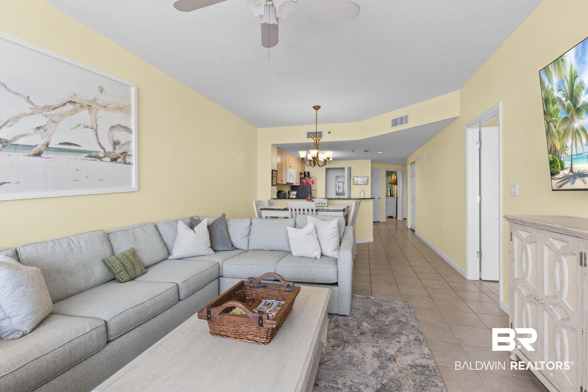 Image 4: Open concept living area with light-toned walls and tile flooring