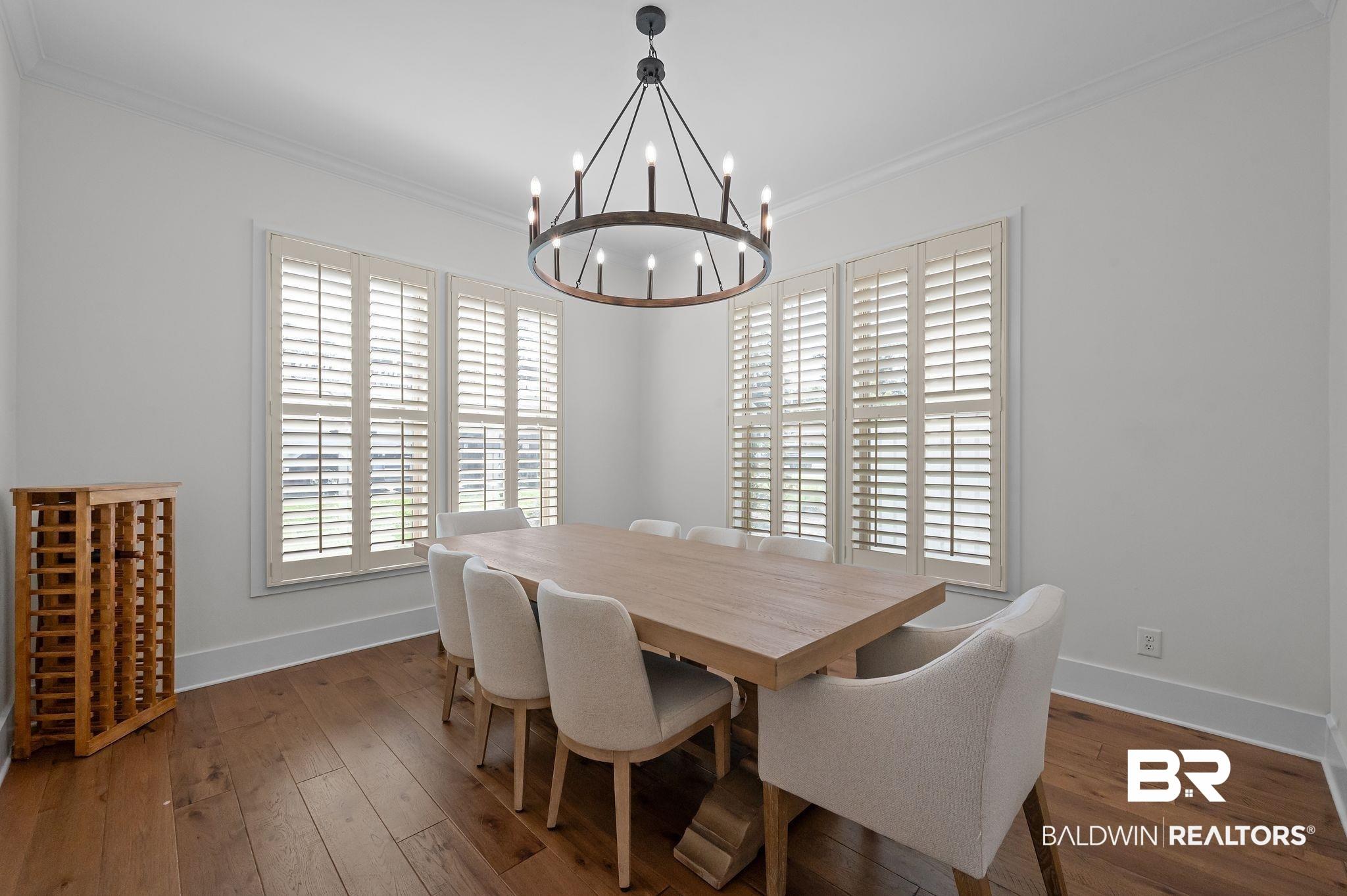 Image 3: Dining room with ornamental molding and dark wood-type flooring