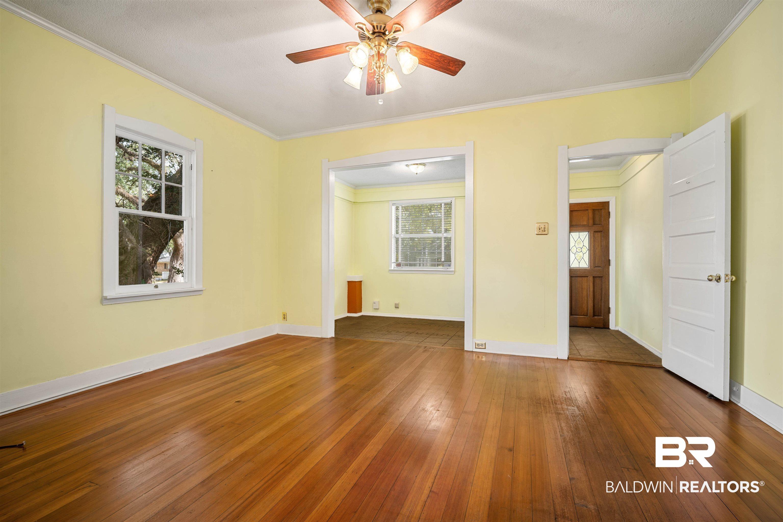 Image 4: Unfurnished room with dark wood finished floors, ornamental molding, and a ceiling fan