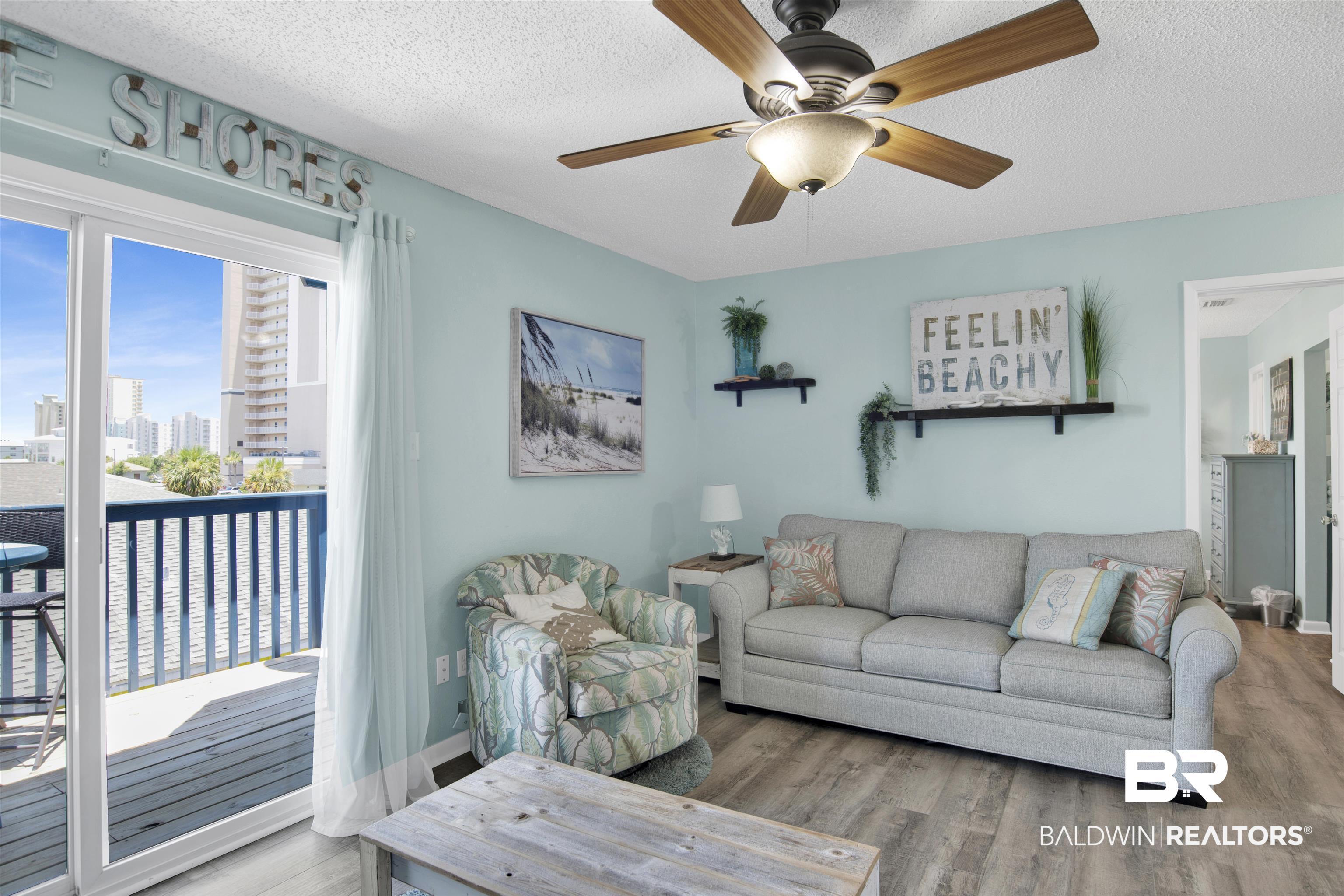 Image 2: Living room with wood finished floors, a textured ceiling, a city view, and ceiling fan