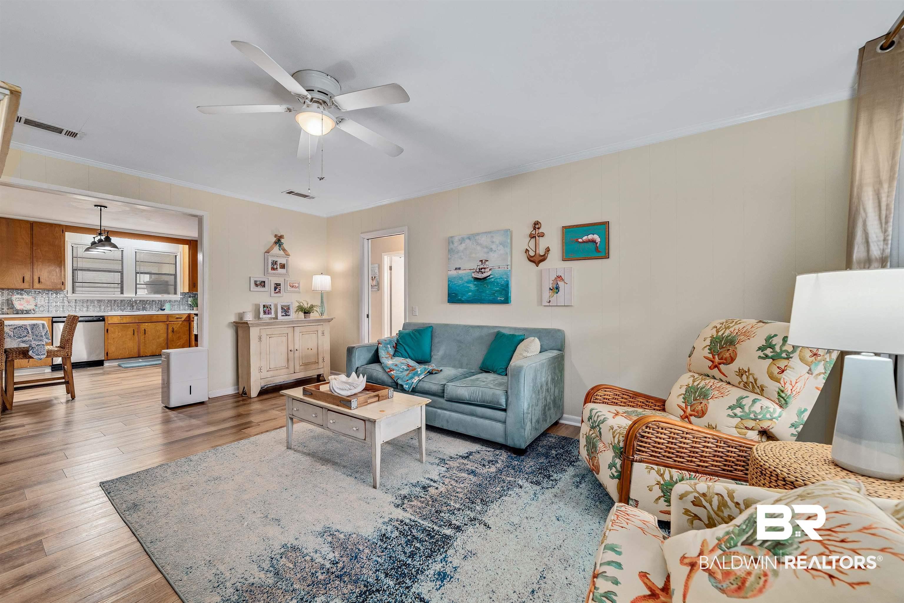 Image 4: Living area featuring ornamental molding, wood finished floors, and a ceiling fan