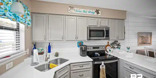 Image 3: Kitchen featuring stainless steel appliances, light stone counters, gray cabinets, and a textured ceiling