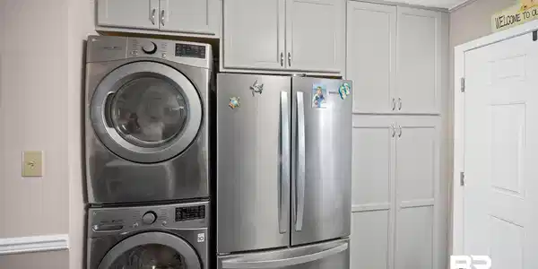 Image 4: Laundry area with stacked washer / dryer, a textured ceiling, and dark wood-style floors