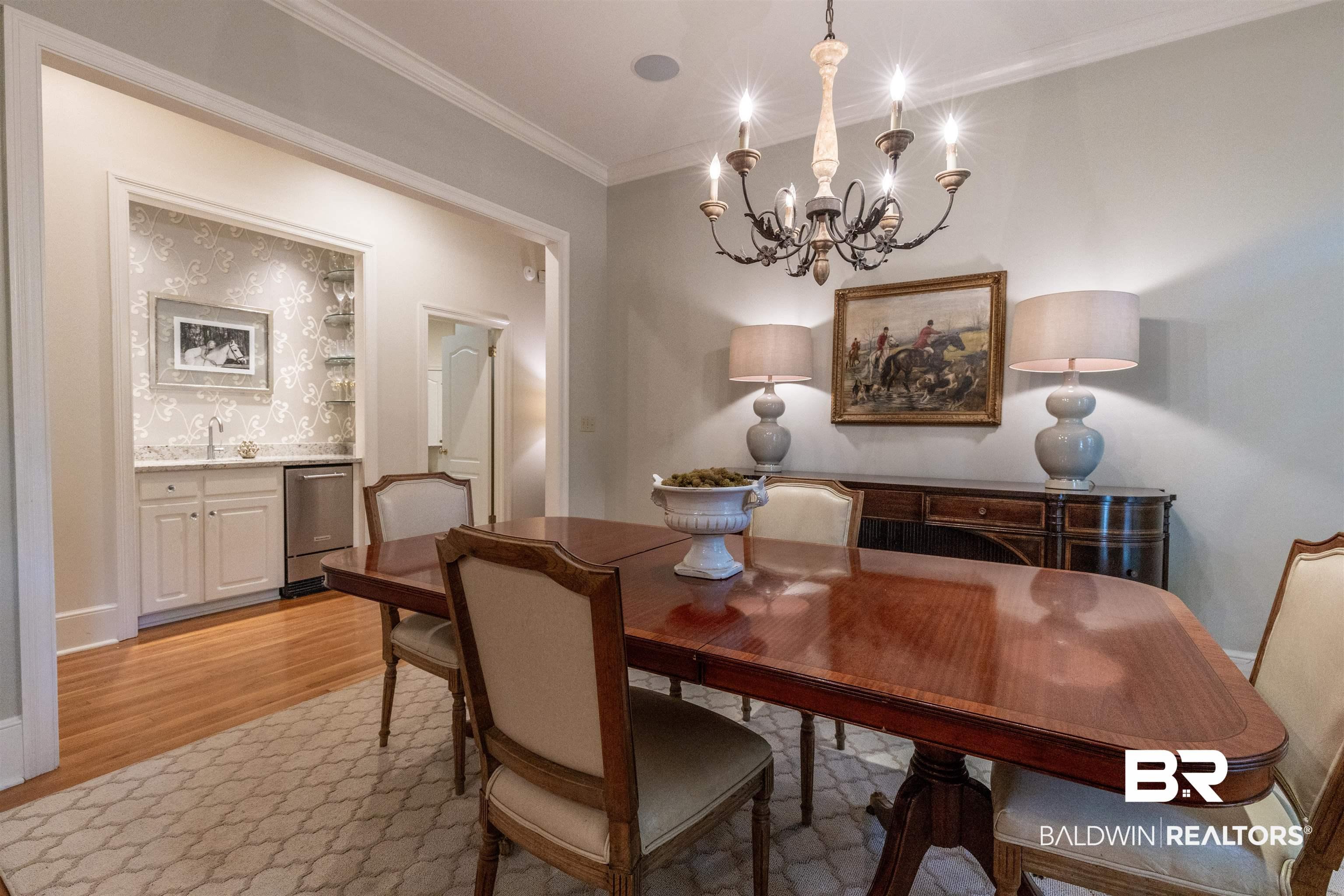 Image 3: Dining room with suspended lighting, crown molding, and light wood-style flooring