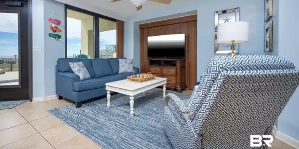 Image 2: Open-concept living space featuring neutral tile flooring, a ceiling fan, and large glass sliding doors providing outdoor access